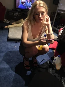Hot Blonde Girl in High-Heeled Shoes and a Skirt Sitting on the Floor at the Party Creepshots