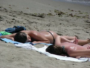 Topless girl with tan lined tits and in a black thong bikini