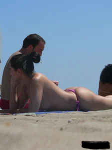 Purple thong topless lady on the beach gets oiled up by her husband