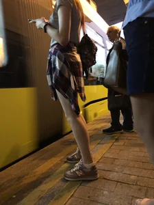 Cute Teen in Shorts on the Tram Stop