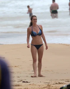 Hottie bikini babe on the beach kicking around a volleyball