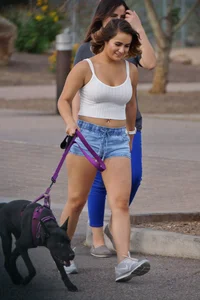 Sexy dog walker in shorts and tank top with friend in blue jeans