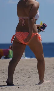 Thick blonde girl in an orange bikini on the beach