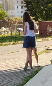 Cute Girl in Denim Skirt with Her Legs Crossed City Candid