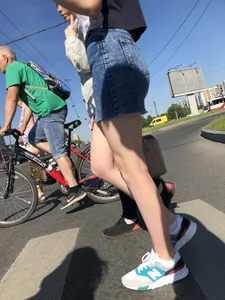 Cute Girl in a Short Denim Skirt Walking on a Street And Waiting on a Crosswalk Gallery