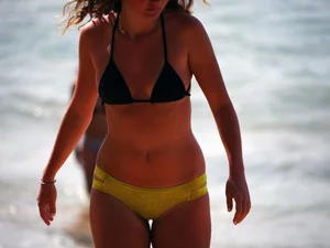 Sexy girl in yellow and black bikini on the beach