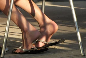 Lady in flop flops while eating showing her feet