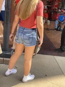 Bunch of girls in various outfits at a Cardinals baseball game