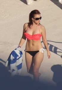 Sexy red haired girl in pink and black bikini at the pool