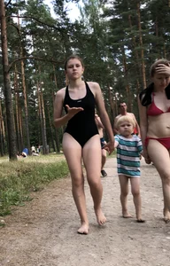 Cute Barefoot Girl in a Black Body Swimsuit Walking on a Road