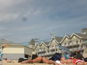 Milf laying out on a beach in Maine in her little thong