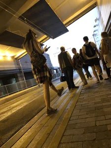 Cute Teen in Shorts on the Tram Stop