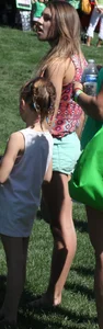 Brunette skinny teen in green shorts playing in a bounce house