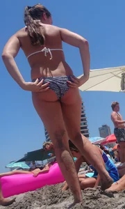 Girls hanging out together at the beach in bikinis and thongs