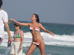 Skinny and sexy lady in a bikini playing on the beach