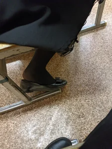 Foot of a College Teen in Black Pantyhose With a Half Taken Off Flat