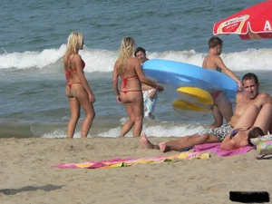 Sexy mom and daughter in red thongs at the beach
