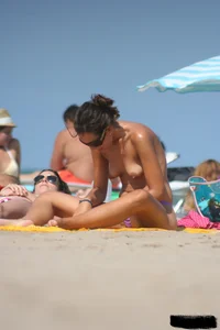 2 topless girls at the beach in thongs