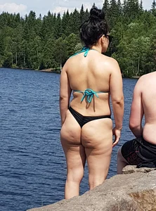 Thick brunette at the lake in a black thong bikini