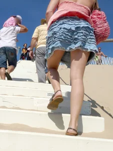 Girl upskirted while walking up stairs at the beach