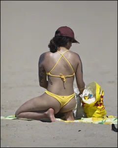 Sexy tattooed beach brunette with a great ass in yellow thong bikini
