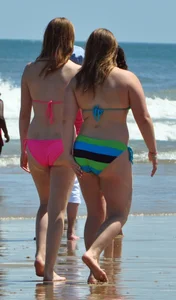 Two beach friends in bikinis one with back dimples and the other thick