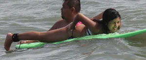 Brunette bikini girl on the beach and surfing in her bikini