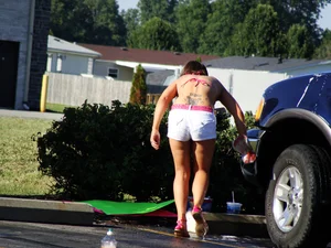 Group of cute girls at a car wash in bikinis and shorts