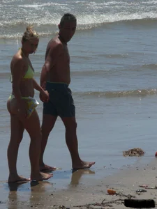 Sexy blonde on the beach in a yellow thong bikini