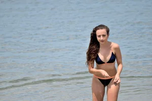 Blue bikini girl on the beach with a great ass and a little pussy lips slips