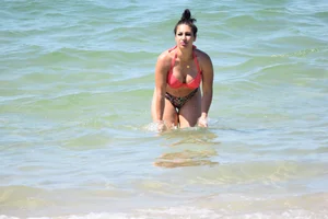 Huge boobed thick brunette babe on the beach in a bikini