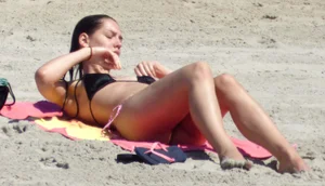Brunette on the beach in a bikini with nice ass and small boobs