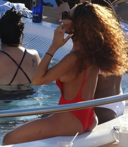 Sexy black girl in red swimsuit at the pool with side boob and a nice ass