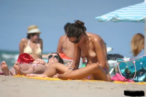 2 topless girls at the beach in thongs