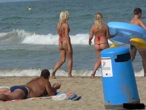 Sexy mom and daughter in red thongs at the beach