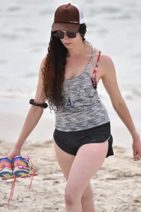 Brunette girl in black shorts and bikini top on the beach