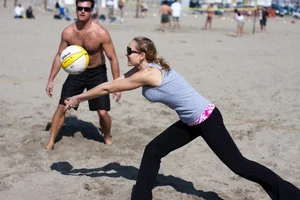 Hot girls playing beach volleyball in bikinis and shorts