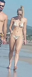 Smooth bodied and sexy blonde at the beach in a thong bikini