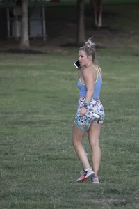 Blonde woman in tight shorts walks her dog