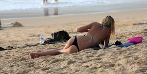 Sexy blonde laying out in black thong bikini