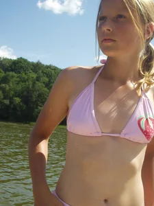 Cute blonde teen wearing a swimsuit by the lake