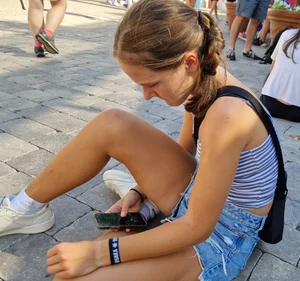 Cute candid teen wearing denim shorts sitting on the ground