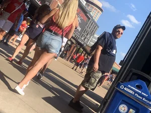 Bunch of girls in various outfits at a Cardinals baseball game