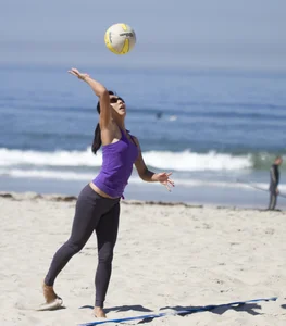 Hot girls playing beach volleyball in bikinis and shorts