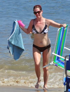 Tattooed redhead milf in a bikini at the beach