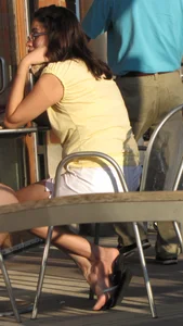 Lady in flop flops while eating showing her feet