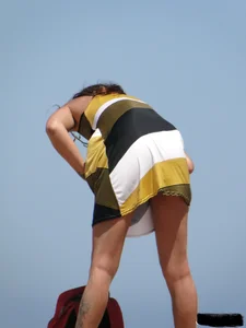Topless lady on the beach in a gold thong with a nice ass