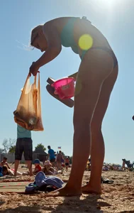 Sexy blonde milf on the beach in blue thong bikini and showing nice camel toe