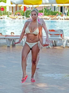 Big boobed blonde milf dancing by the pool in a bikini