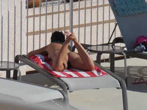 Hot milf sunbathing in a thong by pool and swimming